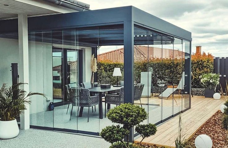 Moderní hliníková pergola s bezrámovým zasklením a jídelním posezením na terase – celoroční využití díky zasklení Hezký stín.