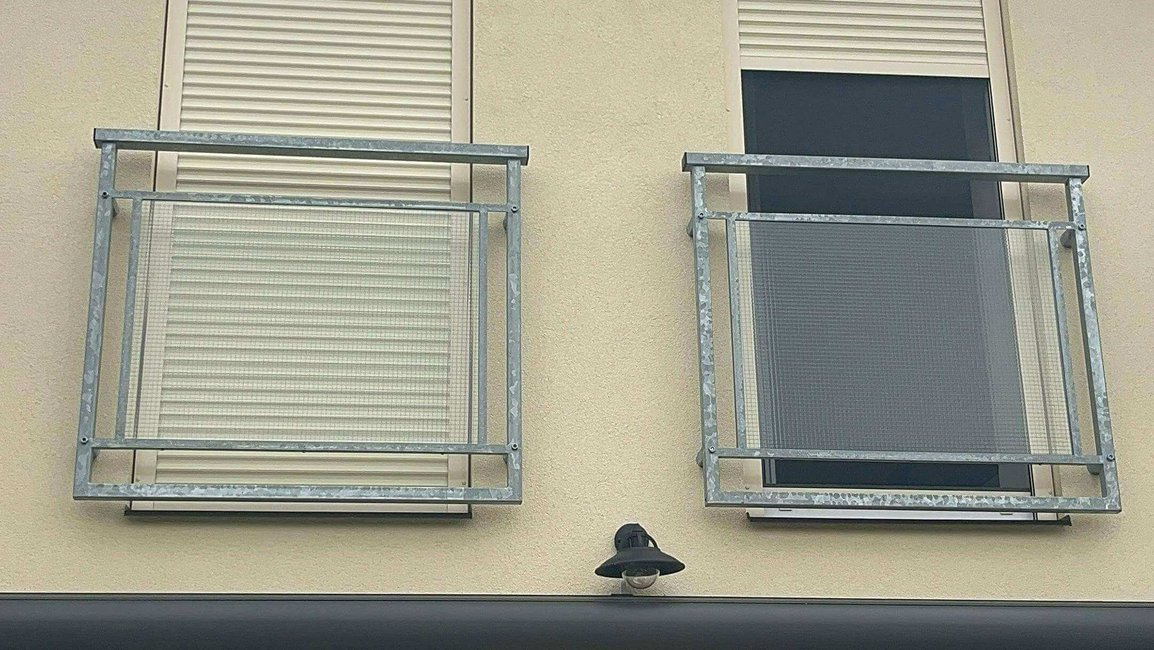 „Venkovní předokenní rolety instalované na fasádě domu, ilustrující jejich designovou eleganci a funkční ochranu proti slunci a hluku.“