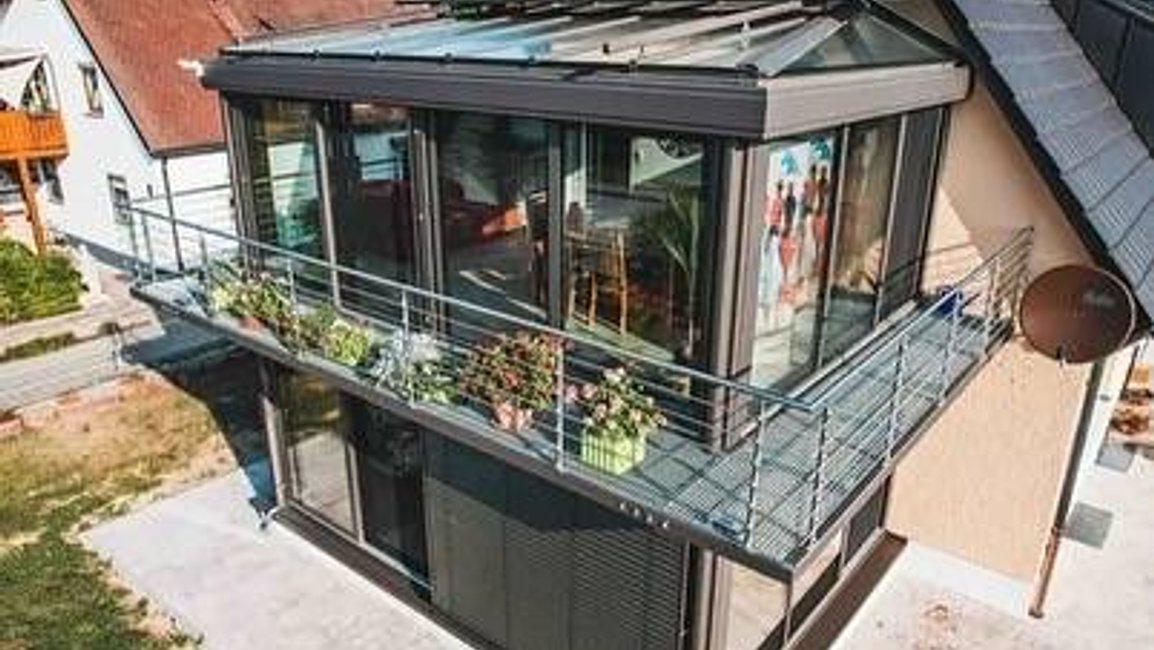 Moderní hliníková zimní zahrada s prosklenou střechou umístěná v patře rodinného domu přináší dokonalé propojení interiéru s exteriérem.