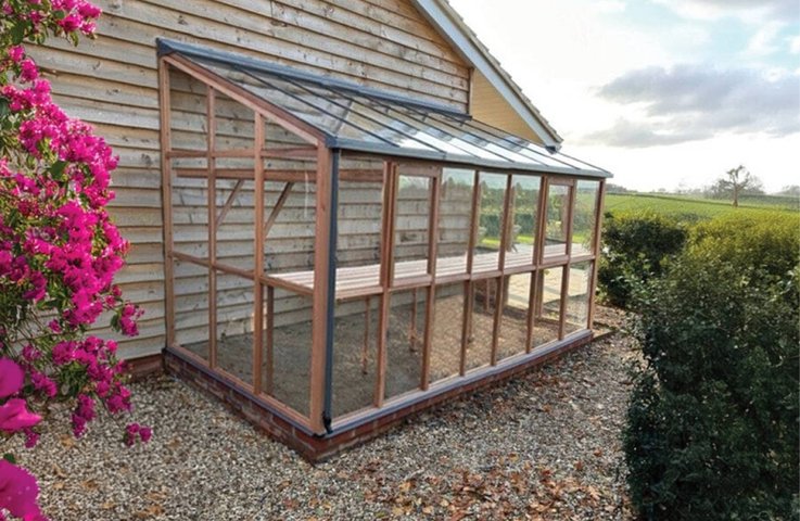 Elegantní skleník typu Lean-to přistavěný k domu nabízí praktické řešení pro menší zahrady. Díky své konstrukci šetří místo, zároveň poskytuje ideální prostředí pro pěstování rostlin po celý rok. Tento klasický přístavkový skleník spojuje estetiku s funkčností a stává se stylovým doplňkem každé moderní zahrady.