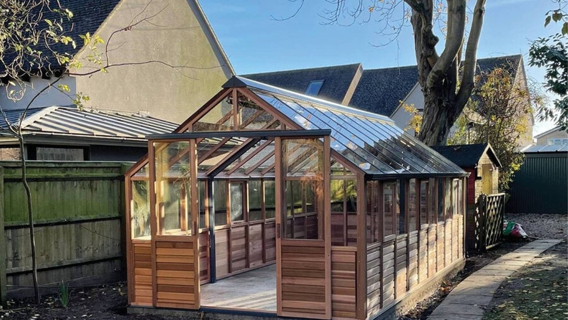 Elegantní dřevěný skleník s prosklenou střechou, který přináší do zahrady harmonii přírody a poskytuje ideální podmínky pro pěstování rostlin i odpočinek.