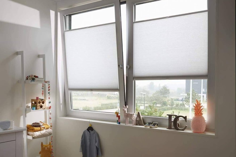 Bílé plisé žaluzie v oknech