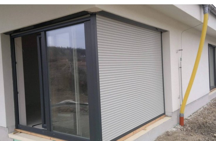 Skrytá předokenní roleta u posuvných dveří – čistý vzhled fasády.