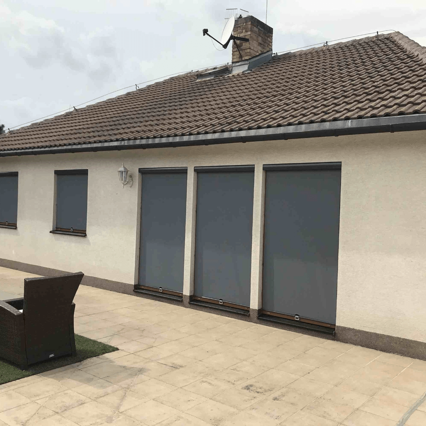 Rodinný dům s šedými screenovými roletami