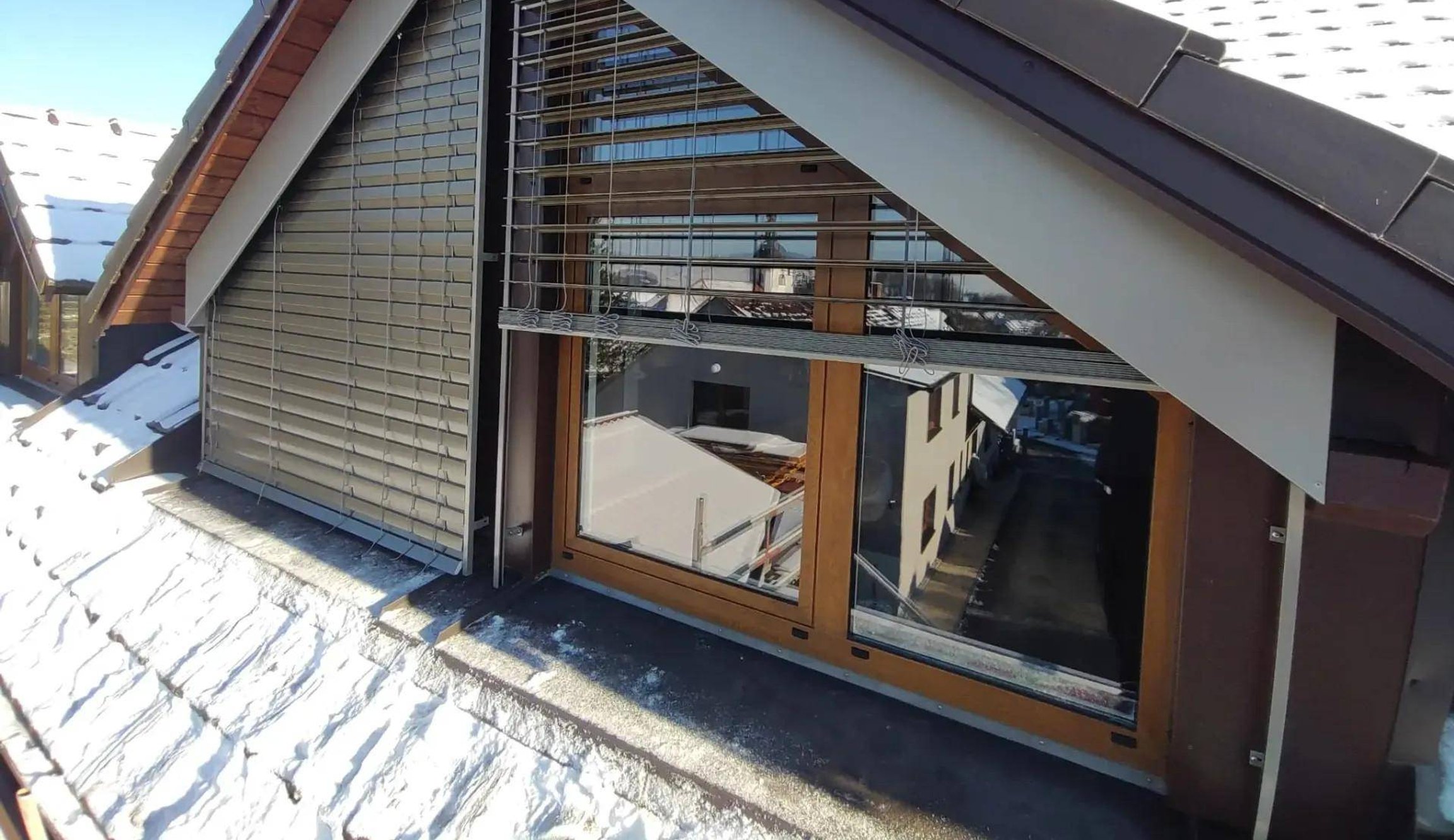 Podkroví domu se šikmými žaluziemi