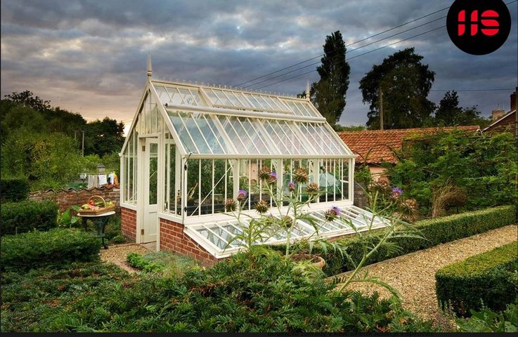 Viktoriánský skleník Aiton v anglickém stylu s cihlovou podezdívkou uprostřed upravené zahrady – luxusní zahradní skleník pro pěstování rostlin po celý rok.