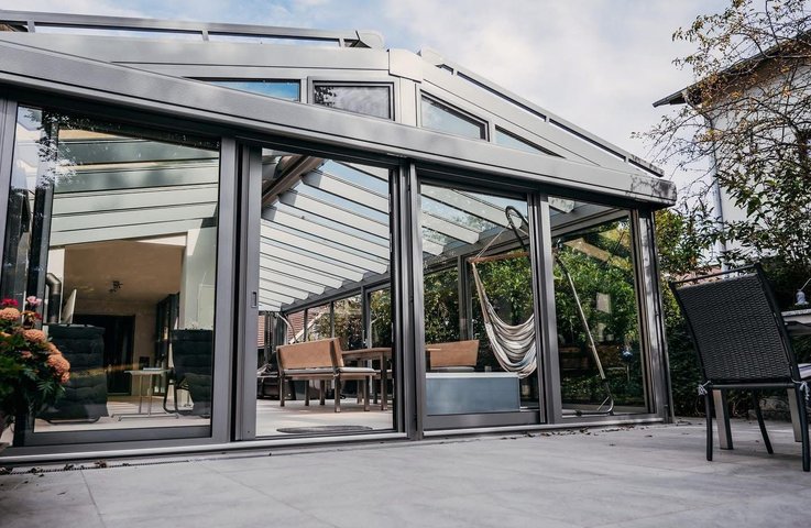 Proč zvolit posuvné dveře místo křídlových? Zjistěte výhody úspory místa, bezbariérového přístupu a moderního designu pro vaši zimní zahradu.