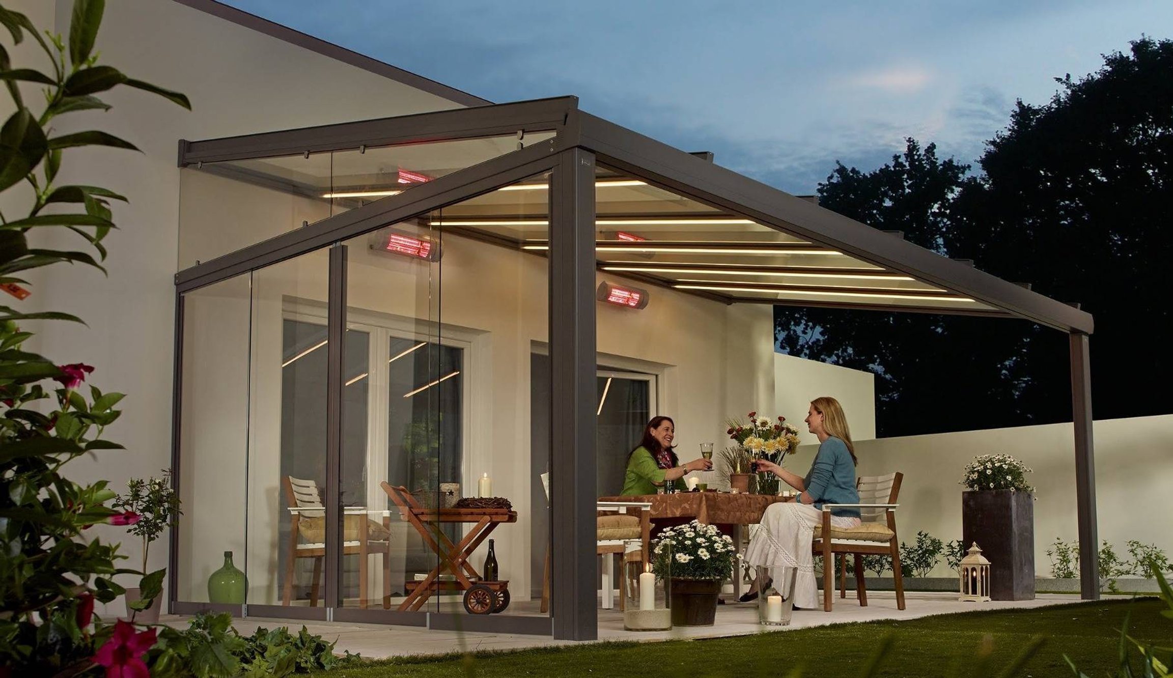 Ženy s vínem sedící pod zastřešenou pergolou